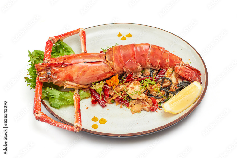 Black pasta stir fried chili with river prawn (Big size) on porcelain plate isolated on white background. The black color of the pasta is caused by the pasta mixed with the black ink of the squid.