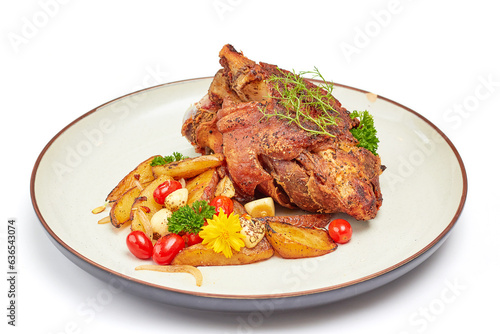 Roasted pork leg with paprika powder and garlic roasted potatoes on porcelain plate isolated on white background.
