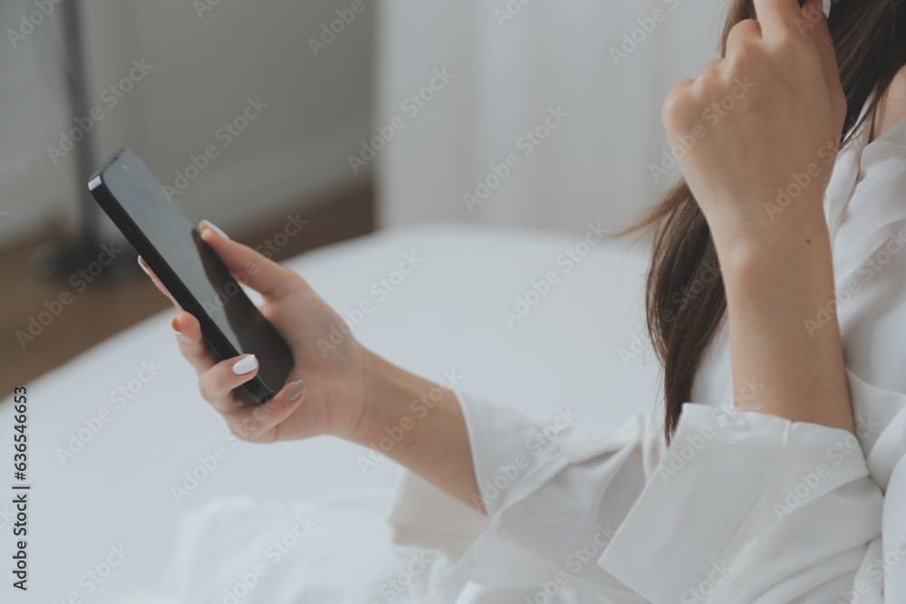 Happy young female in casual clothes smiling and looking at camera while using laptop on bed in bedroom at home Happy young female in casual clothes smiling and looking at camera while using laptop on bed in bedroom at home
