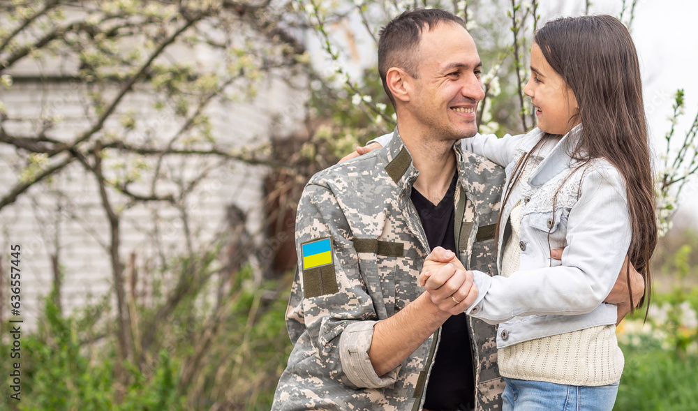 Soldier in Ukrainian military uniform hugging his daughter. Family reunion Soldier in Ukrainian military uniform hugging his daughter. Family reunion