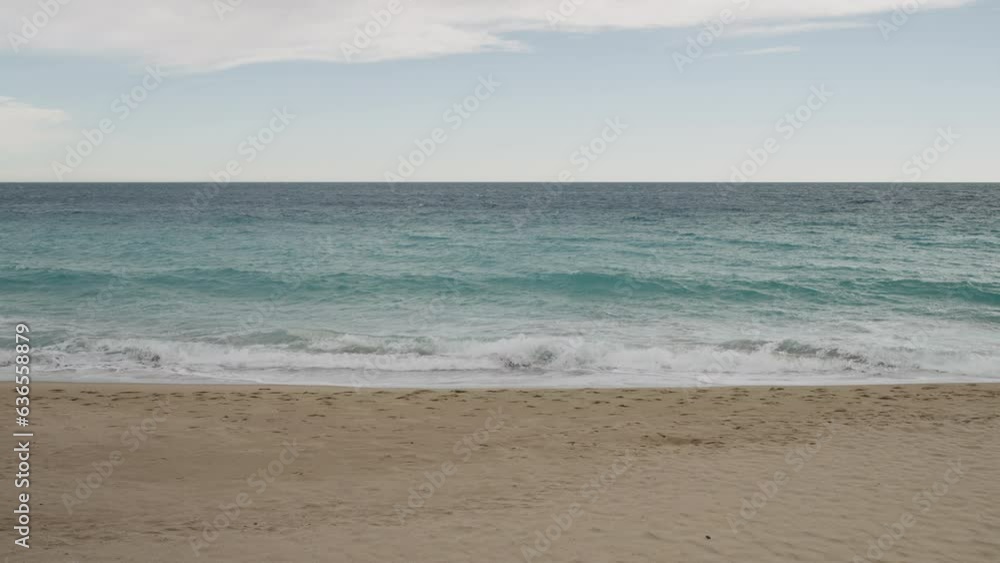 Slow motion clear blue waves with strong wind on a sandy empty beach in Cannes in spring Slow motion clear blue waves with strong wind on a sandy empty beach in Cannes in spring