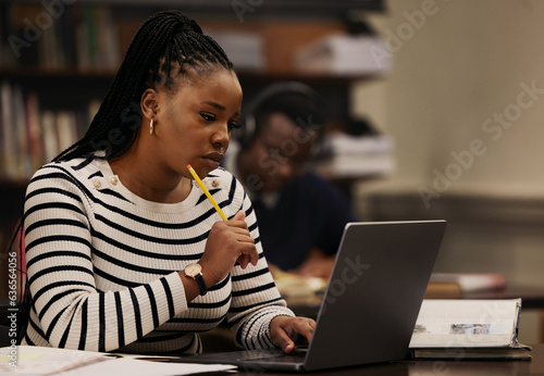 Student, woman and thinking on laptop in library for studying, research and university ideas or focus. Young african person on computer for reading and e learning goals, education or online planning