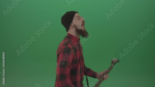 Angry punk rock man guitarist play guitar and scream death hardcore music isolated on green screen photo