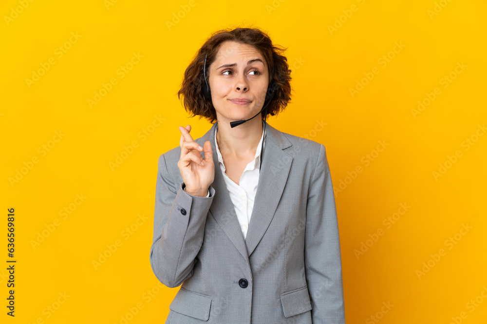 Young English woman isolated on yellow background with fingers crossing and wishing the best Young English woman isolated on yellow background with fingers crossing and wishing the best