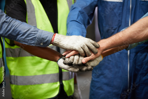workers joining hands for cooperation success work and project in the factory © offsuperphoto