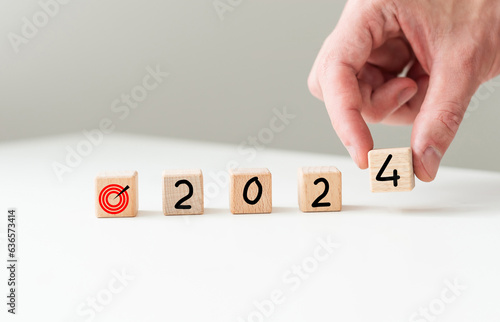 2024 new year goal planning idea, wood block cube on wooden table with new year 2024 and target icon, business vision.