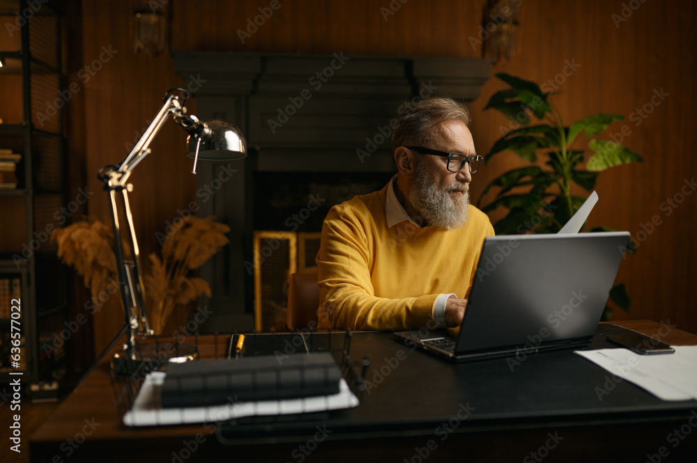 Senior man typing on laptop keyboard working at home office Senior man typing on laptop keyboard working at home office