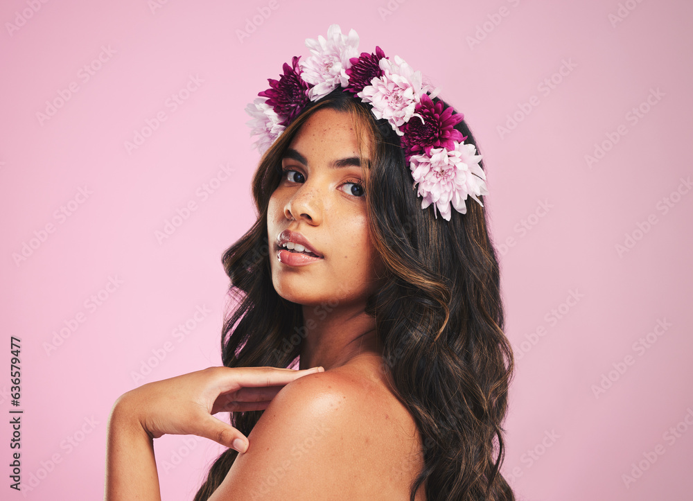 Naklejka premium Woman, flowers and portrait of crown in studio for beauty, natural skincare and spring plants on pink background. Face, model and floral wreath for sustainable cosmetics, eco dermatology or hair care