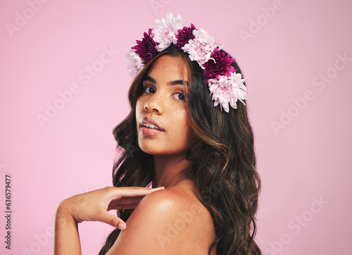 Woman, flowers and portrait of crown in studio for beauty, natural skincare and spring plants on pink background. Face, model and floral wreath for sustainable cosmetics, eco dermatology or hair care