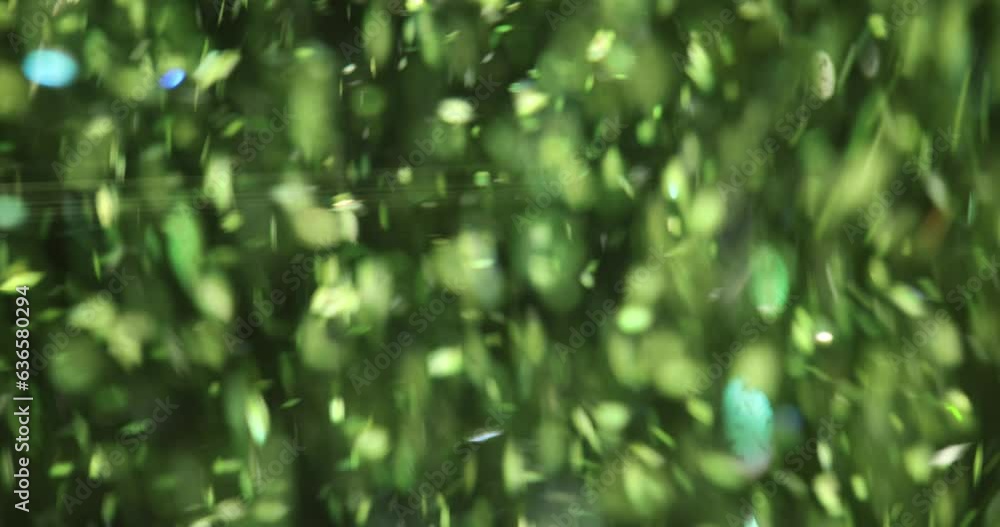 Pieces of colourful green glitter falling on black background of wallpaper. Falling glitter foil confetti concept wallpaper Pieces of colourful green glitter falling on black background of wallpaper. Falling glitter foil confetti concept wallpaper
