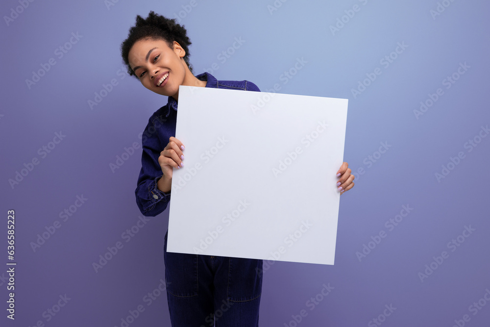 young pretty hispanic business woman with fluffy hair dressed in blue denim suit holding billboard with blank space young pretty hispanic business woman with fluffy hair dressed in blue denim suit holding billboard with blank space