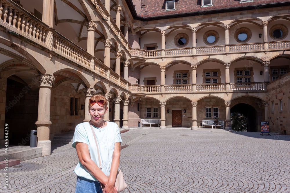 Beautiful mature woman during sightseeing old castle in Stuttgart. Summer time