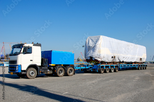 Transport of Oversize Heavy cargo trailera new diesel-electric locomotive on a multi-axle hydraulic modular truck trailer Loading a port area