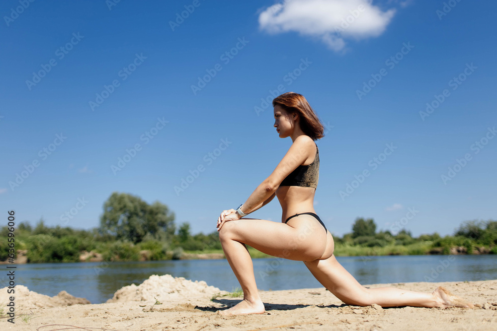 athletic woman doing fitness stretching on the beach in summer athletic woman doing fitness stretching on the beach in summer