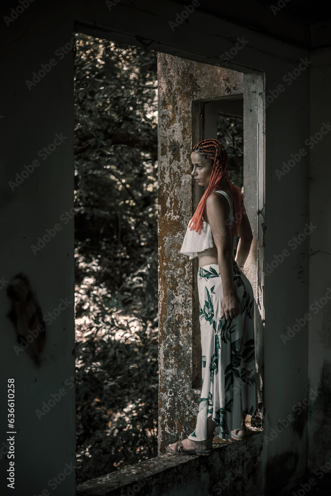 Beautiful girl with orange hair in an abandoned building. Scary abandoned building. Beautiful model girl. Beautiful girl with orange hair in an abandoned building. Scary abandoned building. Beautiful model girl.