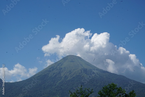 mountain view with clear blue sky covered with thick white clouds
