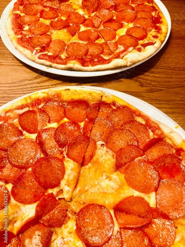 Two restaurant styles pepperoni pizzas 