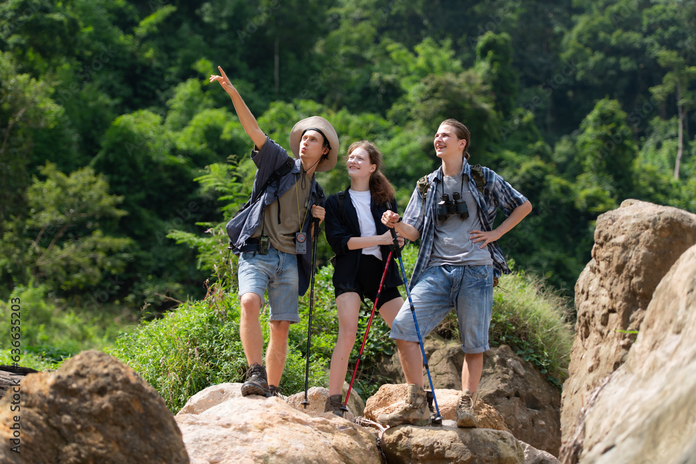Group of tourists with backpacks walking on the trail in the river and mountains