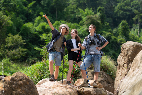 Group of tourists with backpacks walking on the trail in the river and mountains