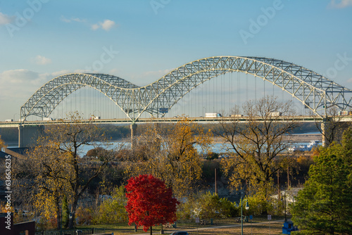 The tied-arch Hernando de Soto Bridge carrying Interstate 40 across the Mississippi River between West Memphis, Arkansas, and Memphis, Tennessee as seen from Mud Island Park on sunset with fall colors