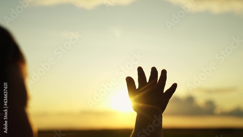 Little girl stretches his hand to sky, dreams in nature. Child is playing. Hand of child boy stretches to beautiful sky, sunset. Childrens dreams hopes, reach out your hands to sky. Childrens prayer