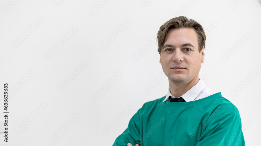 Confident doctor stands with arm crossed ready to work on his mission in front of his operation room. Confident doctor stands with arm crossed ready to work on his mission in front of his operation room.