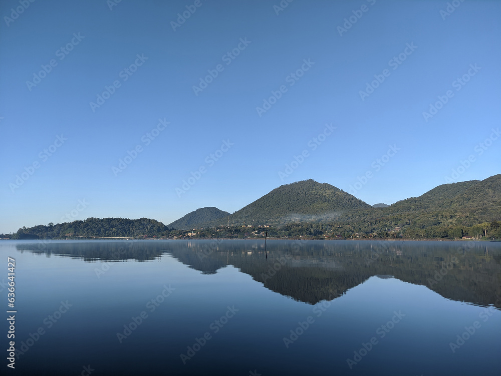 Morning view of Beratan Lake, Tabanan, Bali, water reflection from the hills around the lake. Morning view of Beratan Lake, Tabanan, Bali, water reflection from the hills around the lake.