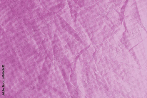 Wrinkled, crumpled pink fabric texture background. Wrinkled and creased abstract backdrop of spunbond textile, wallpaper with copy space, top view.