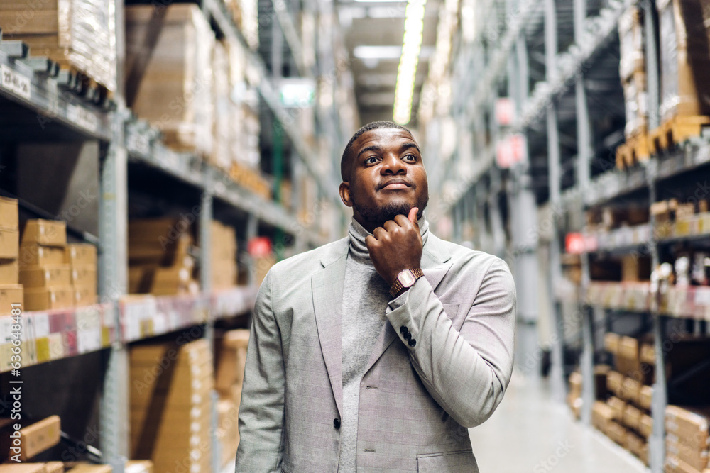Portrait of smiling african american business man order details on tablet checking goods and supplies on shelves with goods background in warehouse.logistic and business export Portrait of smiling african american business man order details on tablet checking goods and supplies on shelves with goods background in warehouse.logistic and business export