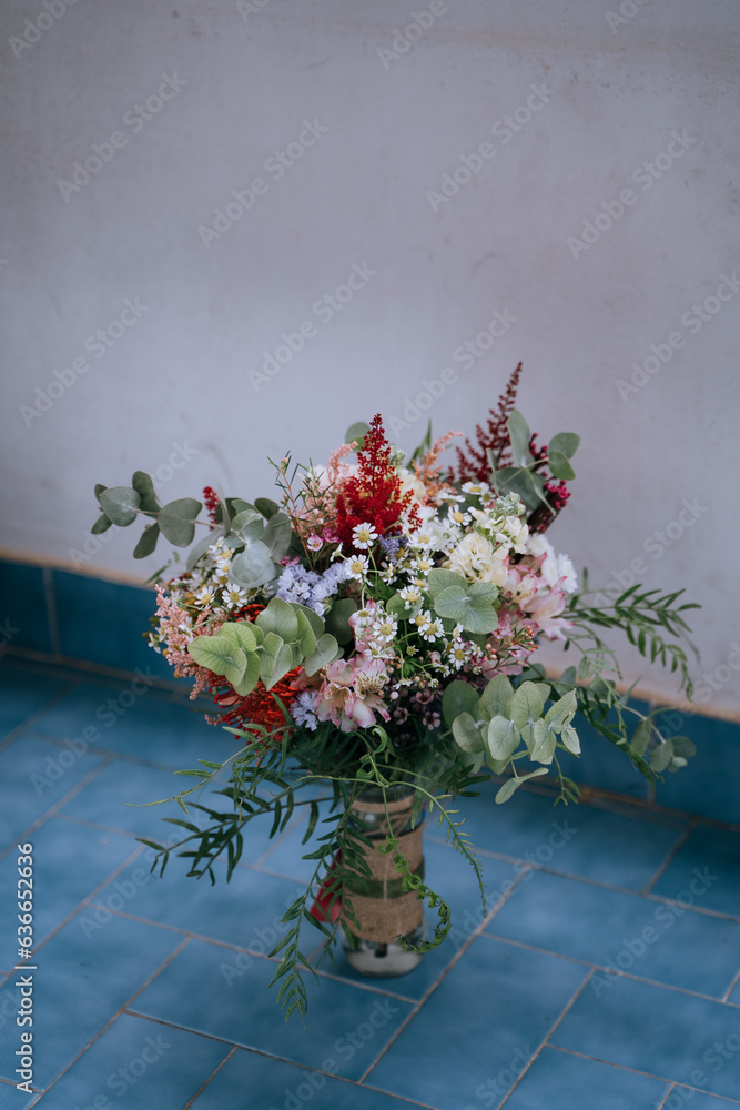 Ramo de flores de boda en jarrón sobre azulejos