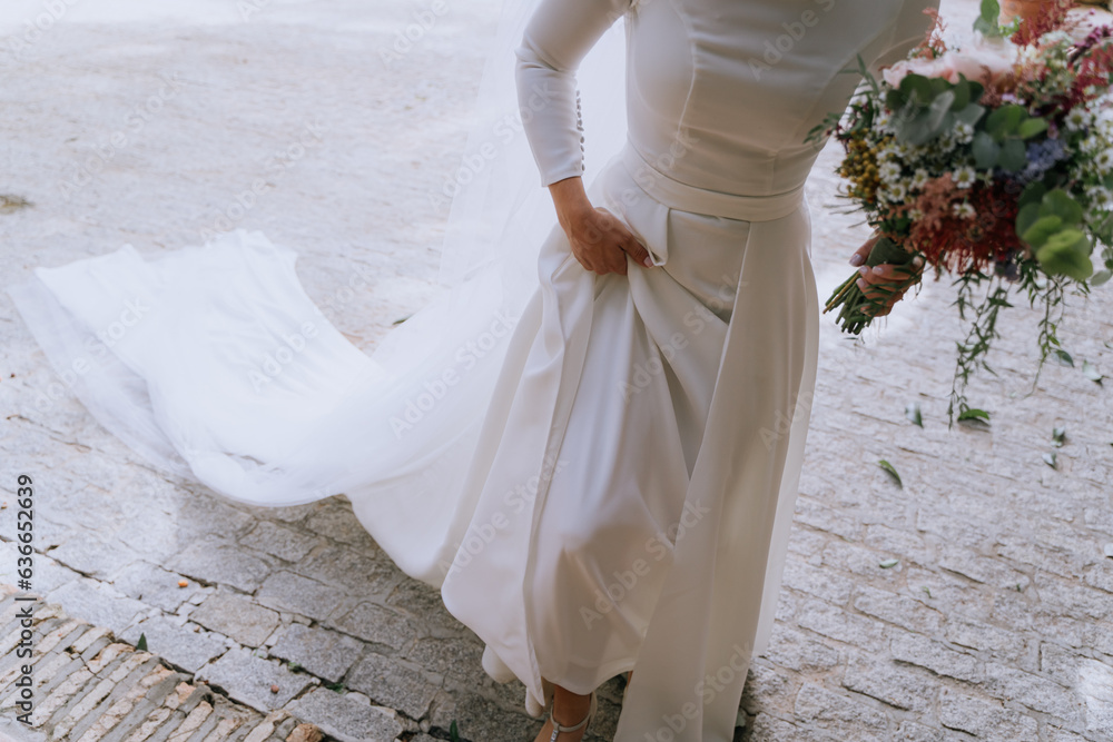 Novia subiendo escaleras con ramo de flores
