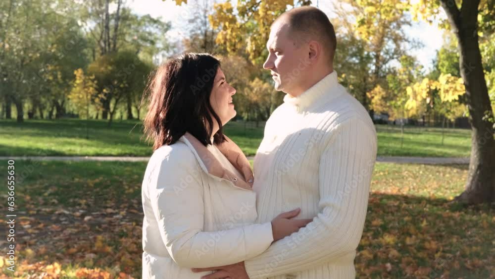Husband and wife on a walk in the autumn park. The couple looks at each other lovingly. Horizontal video Husband and wife on a walk in the autumn park. The couple looks at each other lovingly. Horizontal video