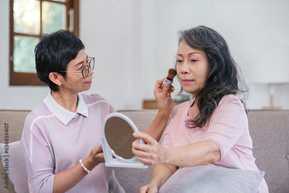 An elderly woman happily spends her free time make up with friends in the living room. An elderly woman happily spends her free time make up with friends in the living room.