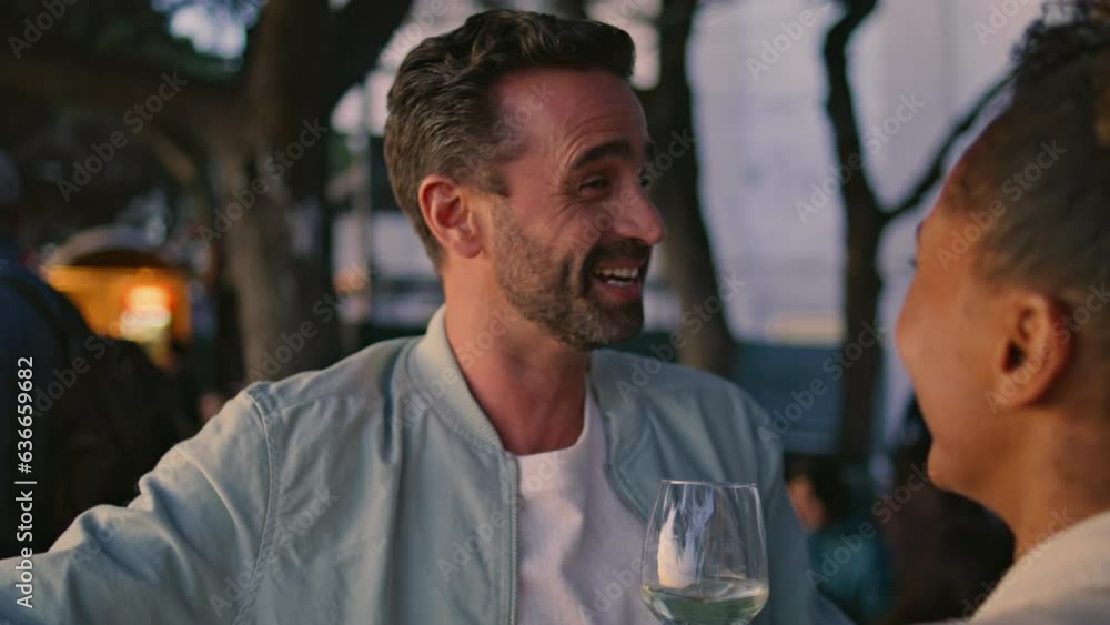 Laughing lovers having fun at evening bar rooftop close up. Multiracial people Laughing lovers having fun at evening bar rooftop close up. Multiracial people