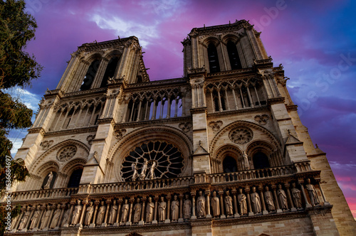 The imposing front of Notre Dame Cathedral in Paris with a dramatic sky.
