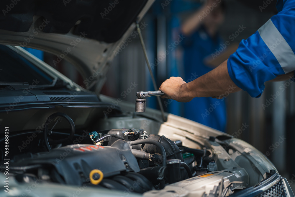 Asian mechanic repairing a car in auto repair shop. Asian mechanic repairing a car in auto repair shop.