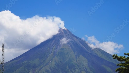 White ash clouds emit from Mayon volcano crater on a clear day photo