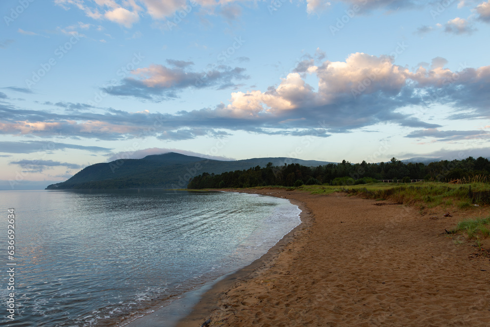 A cape, the bay and the St. Lawrence River seen from the beach during a beautiful summer sunrise, Baie-Saint-Paul, Charlevoix, Quebec, Canada