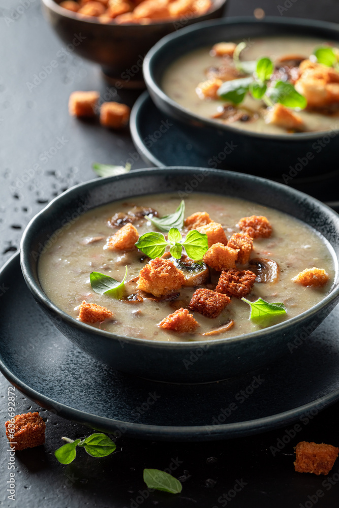 Creamy mushrooms soup with champignons and croutons.