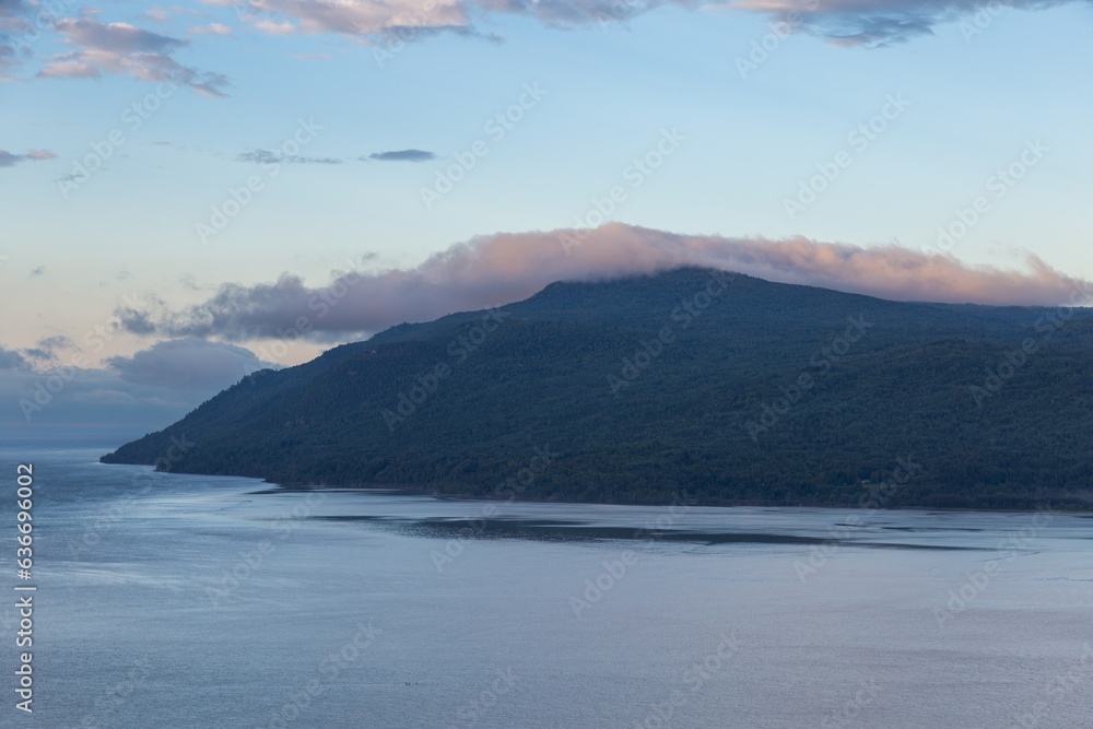 A Laurentian mountains cape covered in forest and the St. Lawrence River seen during a beautiful summer sunrise, Baie-Saint-Paul, Charlevoix, Quebec, Canada