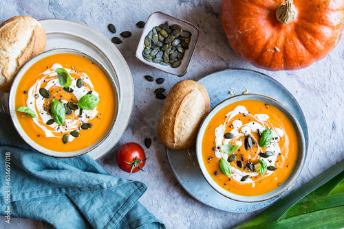 Pumpkin and Tomato cream soup topped with sour cream, pumpkin seeds and basil