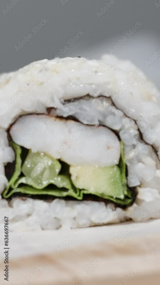 Vertical video. Sushi roll with avocado and shrimp, close-up shot. Vertical video. Sushi roll with avocado and shrimp, close-up shot.