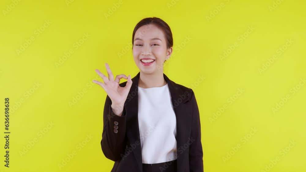 Portrait young asian business woman presenting and gesture ok isolated on yellow background, advertising and marketing, executive and manager, businesswoman confident showing with expression. Portrait young asian business woman presenting and gesture ok isolated on yellow background, advertising and marketing, executive and manager, businesswoman confident showing with expression.