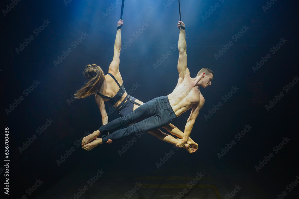 Aerial straps duo performance a man and woman execute graceful