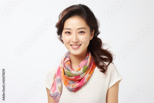 Medium shot portrait of a Chinese woman in her 30s in a white background wearing a foulard