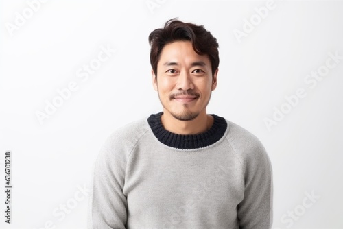 Medium shot portrait of a Chinese man in his 30s in a white background wearing a cozy sweater