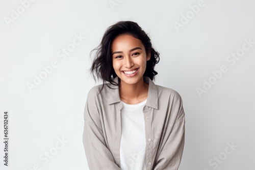 Medium shot portrait of a Indonesian woman in her 20s in a white background wearing a chic cardigan