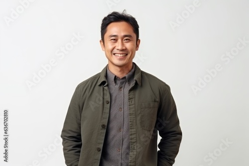 Portrait of a happy young asian man smiling against white background