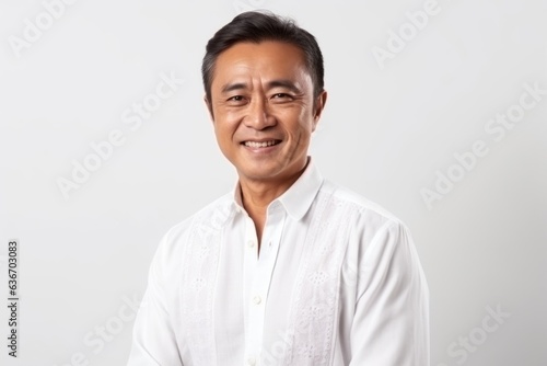 Portrait of a happy asian man in white shirt on white background © Anne-Marie Albrecht