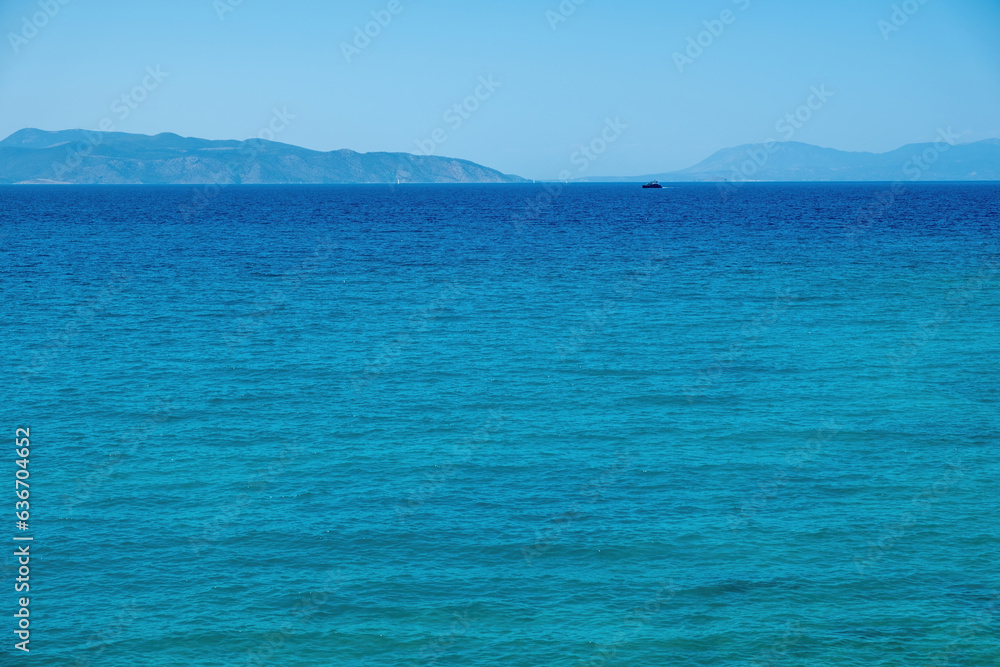Ship sails in vast Mediterranean sea under Greek blue sky background. Summer destination, space. Ship sails in vast Mediterranean sea under Greek blue sky background. Summer destination, space.